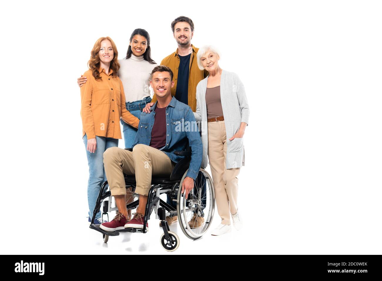 Des amis multiculturels qui s'embrasent près d'un homme souriant en fauteuil roulant isolé blanc Banque D'Images