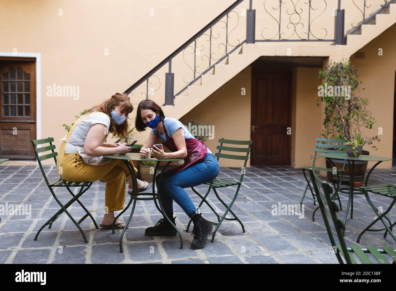 Deux potiers caucasiens assis près d'une table à l'extérieur du studio de poterie Banque D'Images