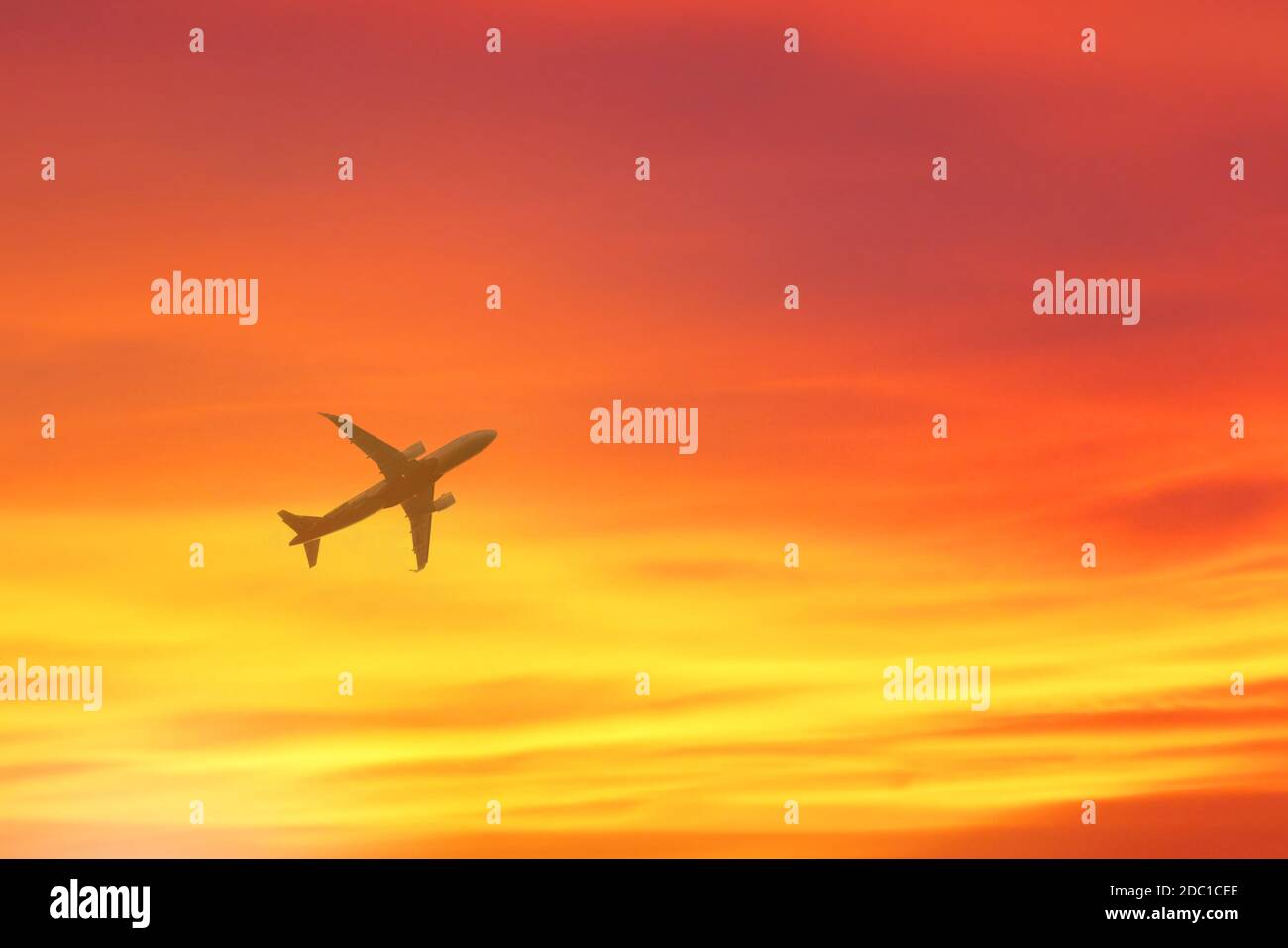 Avion survolant avec fond de coucher de soleil. Banque D'Images