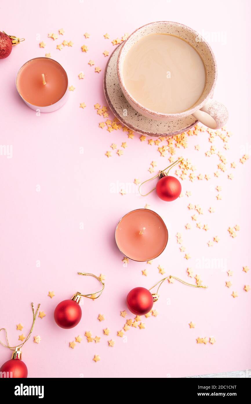 Composition de Noël ou du nouvel an. Décorations, boules rouges, tasse de café, sur fond de papier rose. Vue de dessus, espace de copie, plan de travail. Banque D'Images