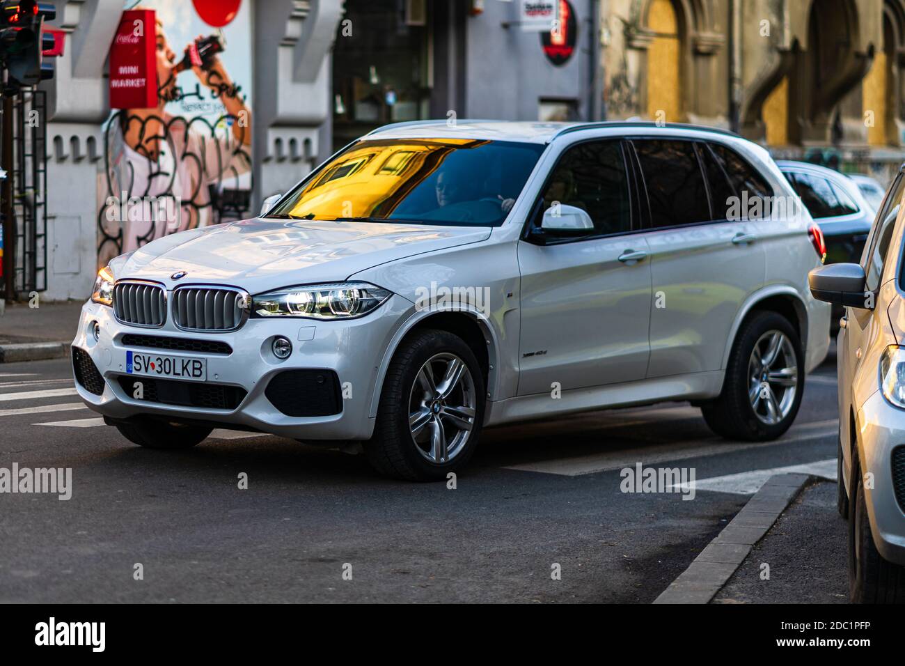 BMW blanche x5 en mouvement sur route asphaltée, vue latérale de la voiture sur la rue. Bucarest, Roumanie, 2020 Banque D'Images