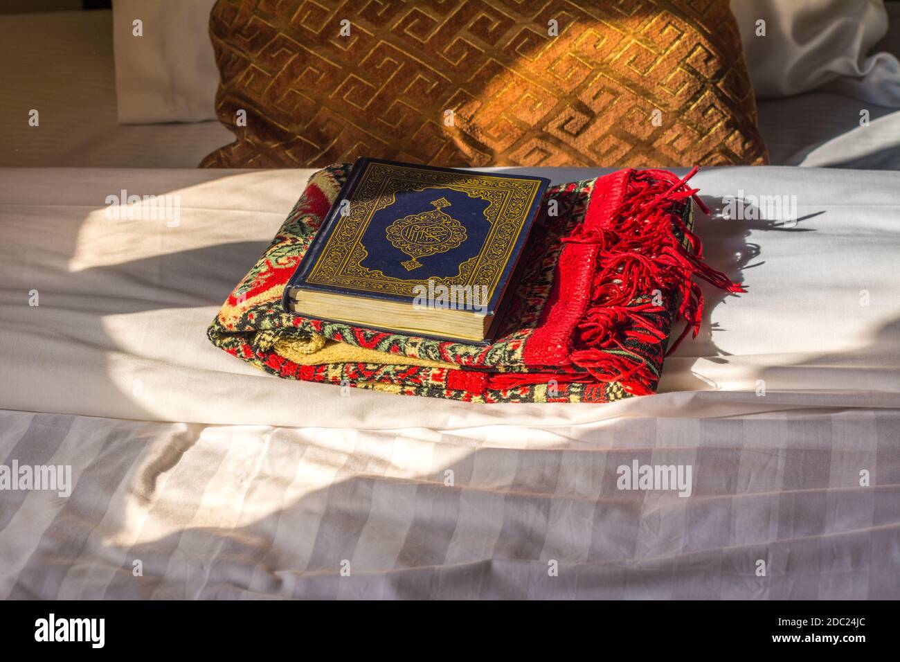 Bible du Coran et foulard sur le lit avec fond De l'oreiller sous la  lumière du soleil dans l'hôtel de l'Arabie Saoudite Photo Stock - Alamy