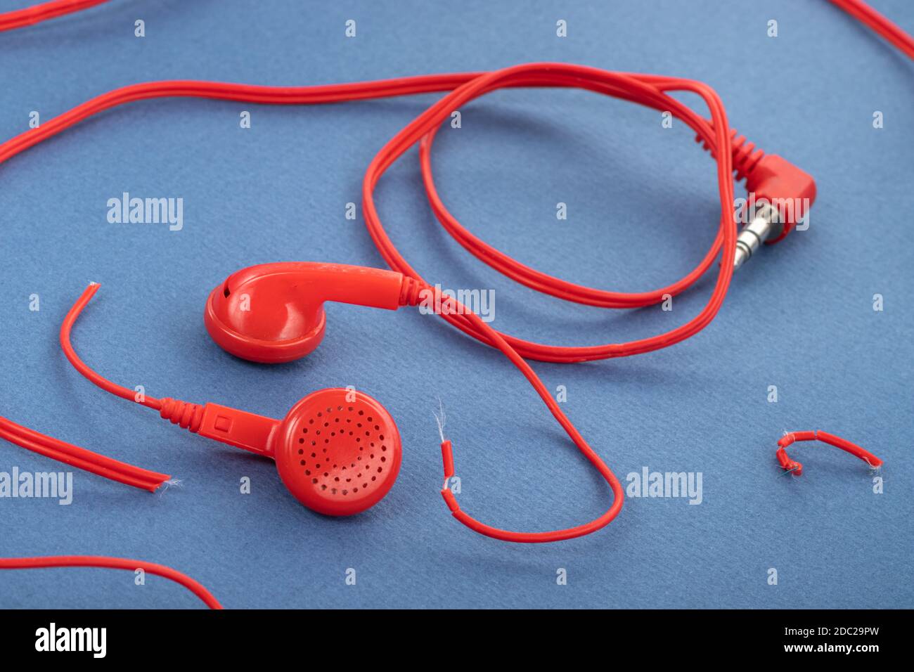 Casque sur fond bleu. Écouteurs déchirés. Réparation de dispositifs  électroniques. Fil cassé Photo Stock - Alamy