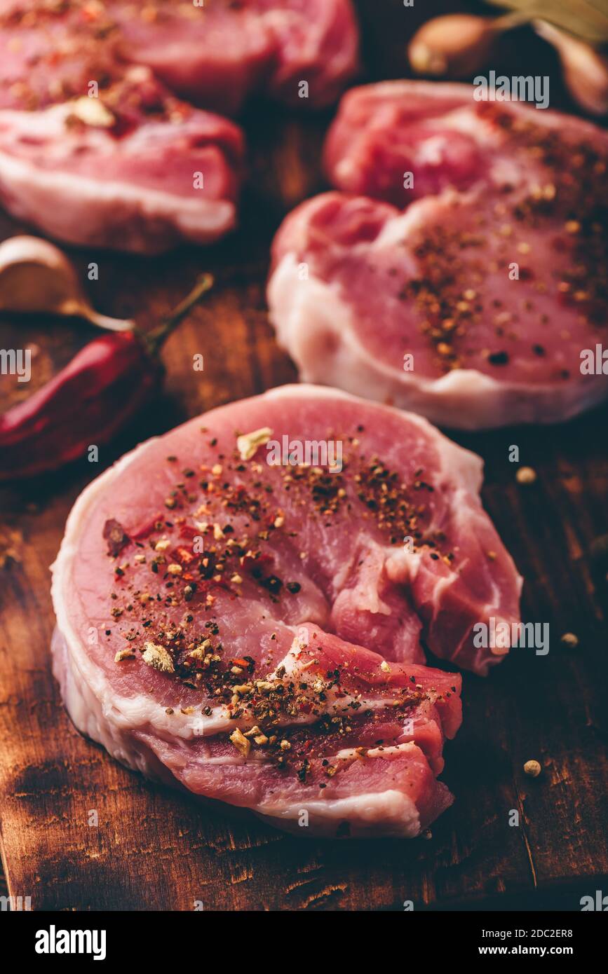 Contre-filets de porc avec épices moulues sur planche à découper rustique Banque D'Images
