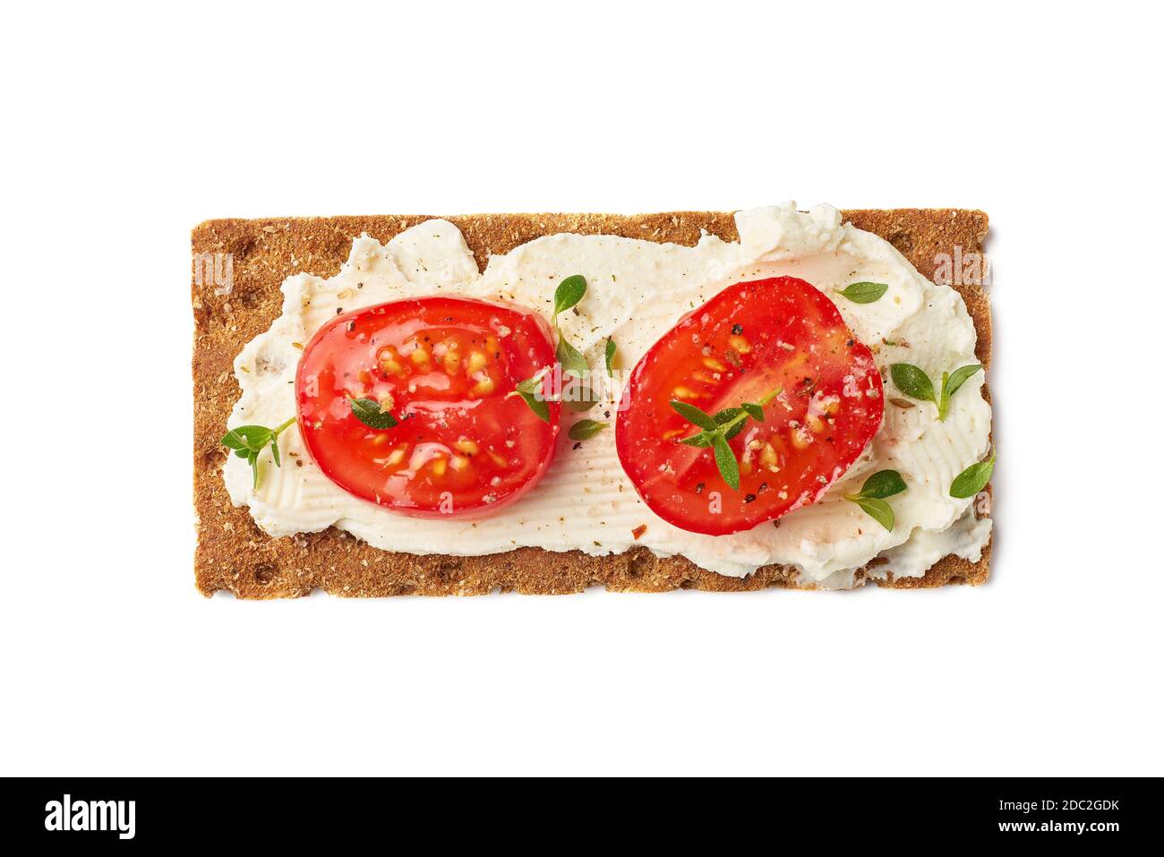 Pain croustillant avec fromage à la crème et tranches de tomate sur blanc Banque D'Images