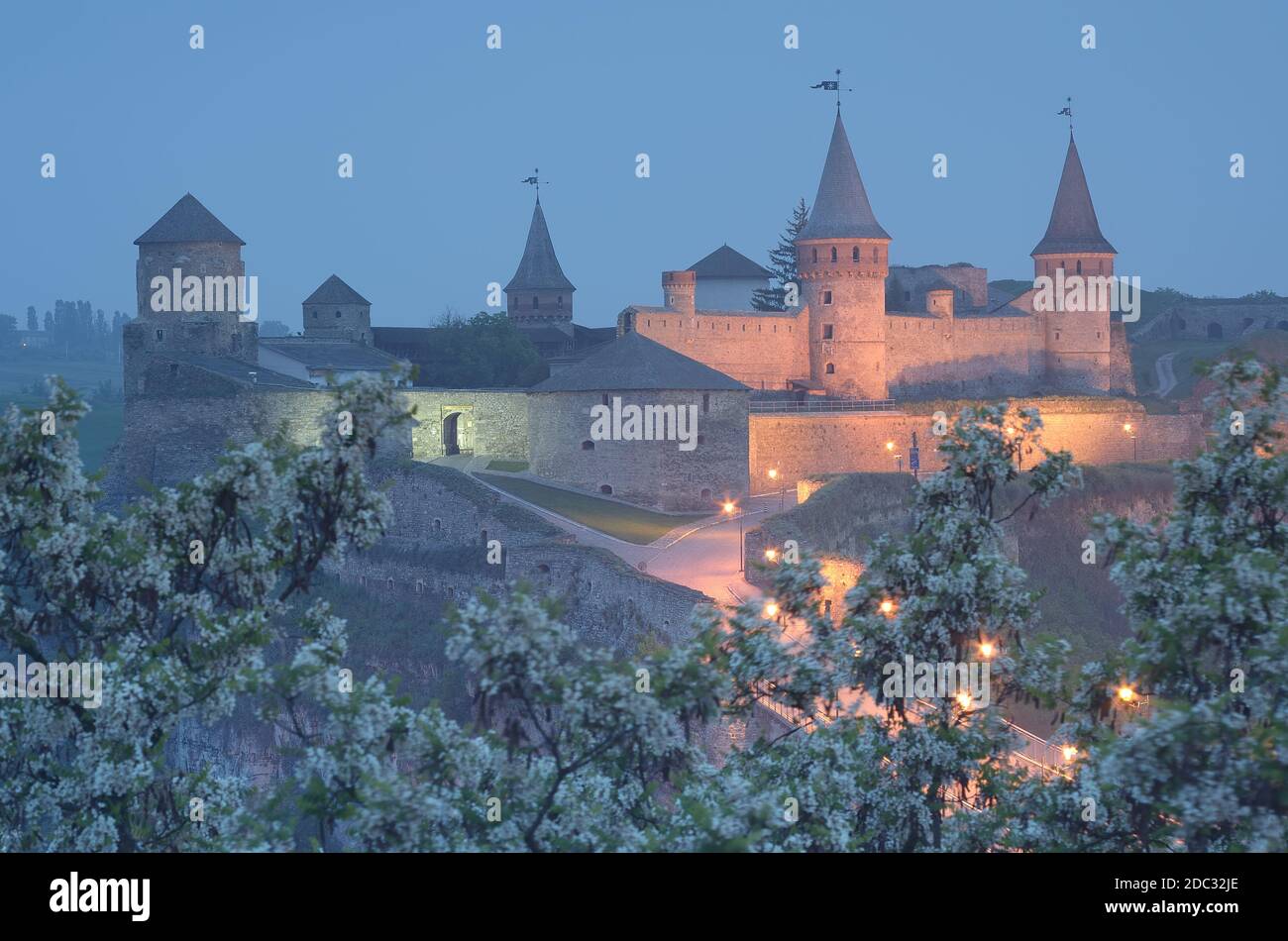 Paysage de nuit avec une route menant à l'ancienne forteresse. Illumination dans un bâtiment historique. Site historique. Vieille ville de Kamenetz-Podolsk, Ukraine Banque D'Images