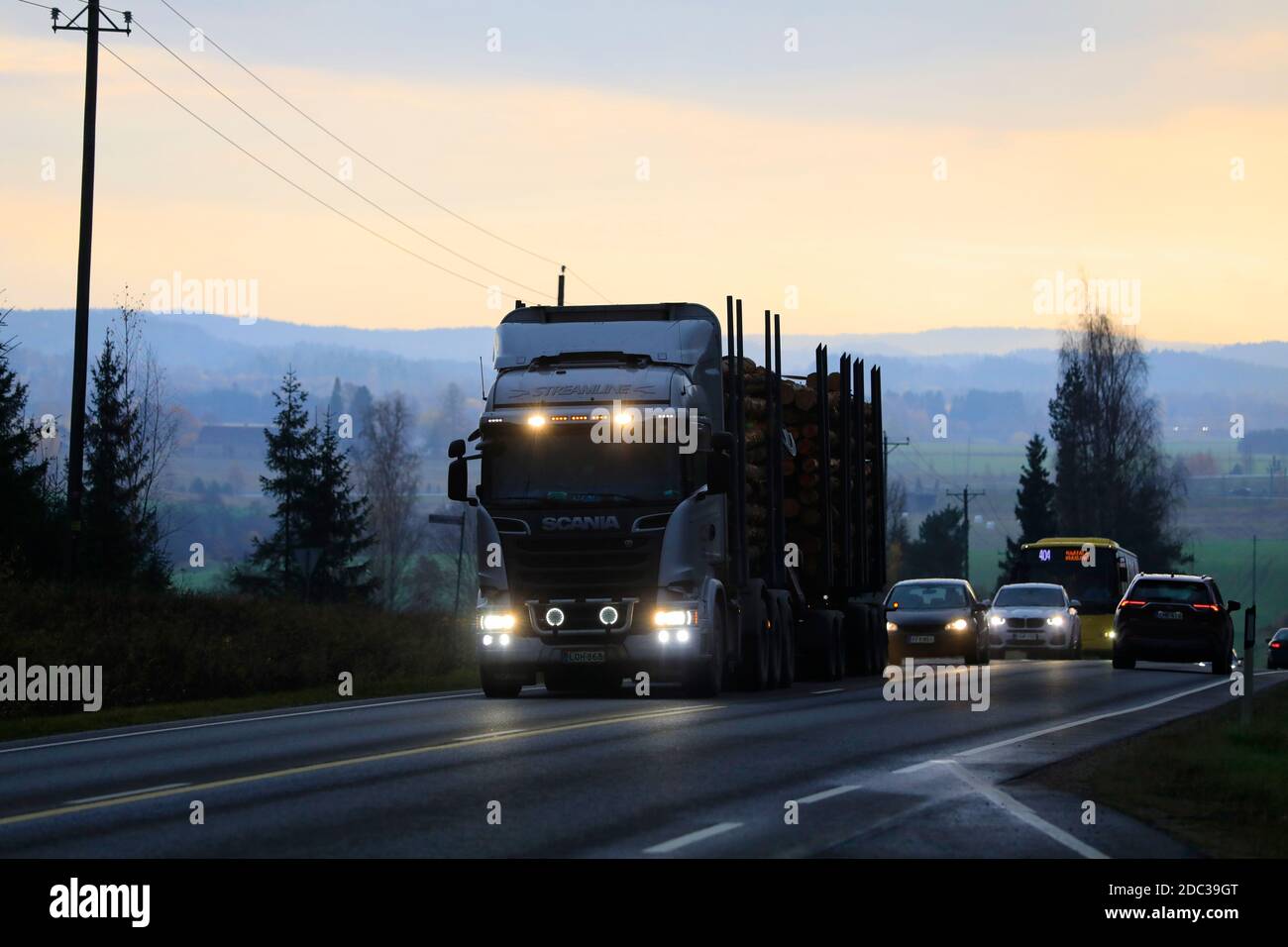Silver Scania R730 rationalise le transport de la charge des grumes par camion-grumes dans la circulation routière à la tombée de la nuit de l'automne. Salo, Finlande. 30 octobre 2020. Banque D'Images