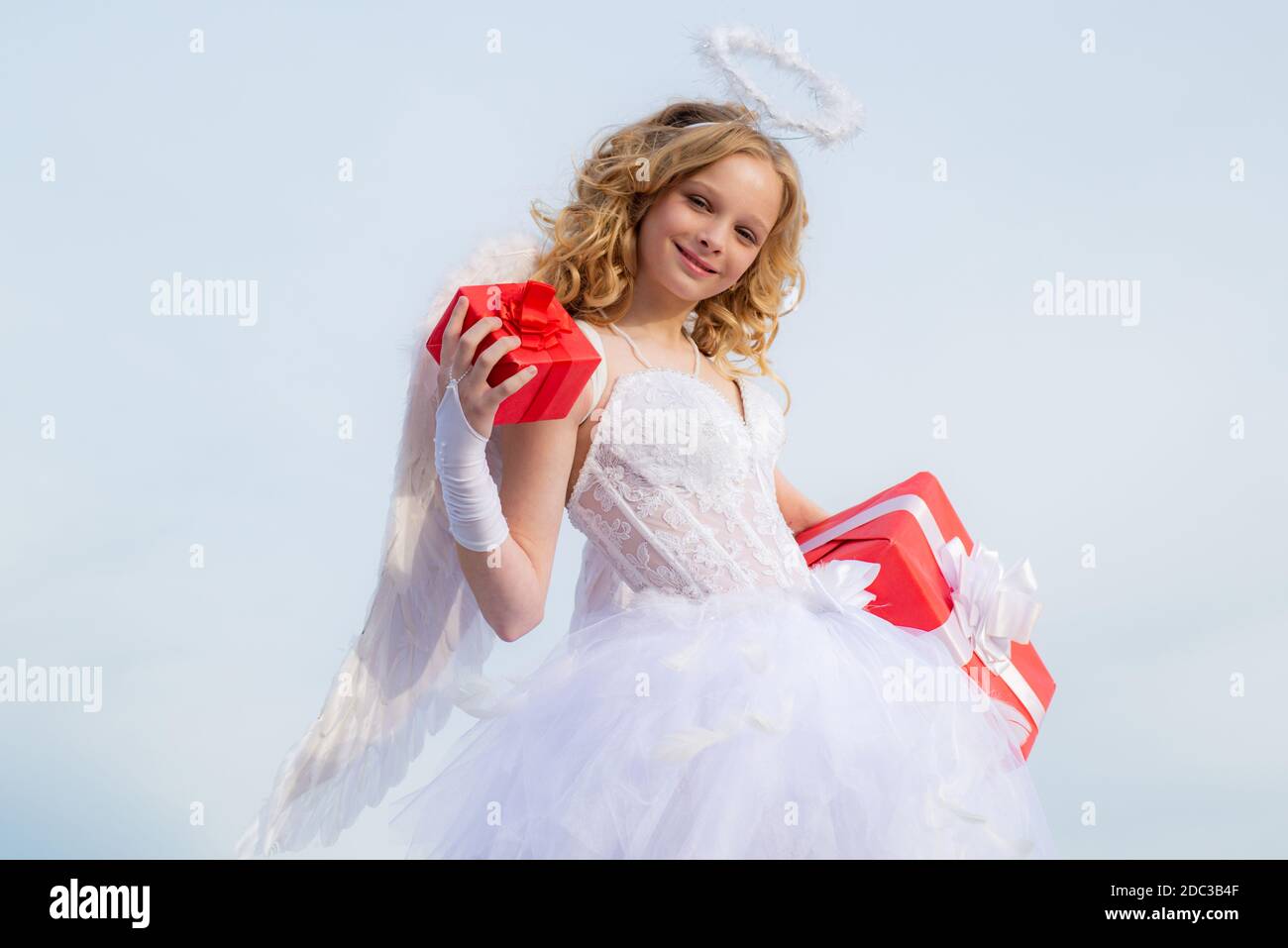 Petite fille portant un costume d'ange robe blanche et ailes de plumes.  Petit ange Cupidon mignon avec cadeau. Carte de voeux à motif art festif  Photo Stock - Alamy