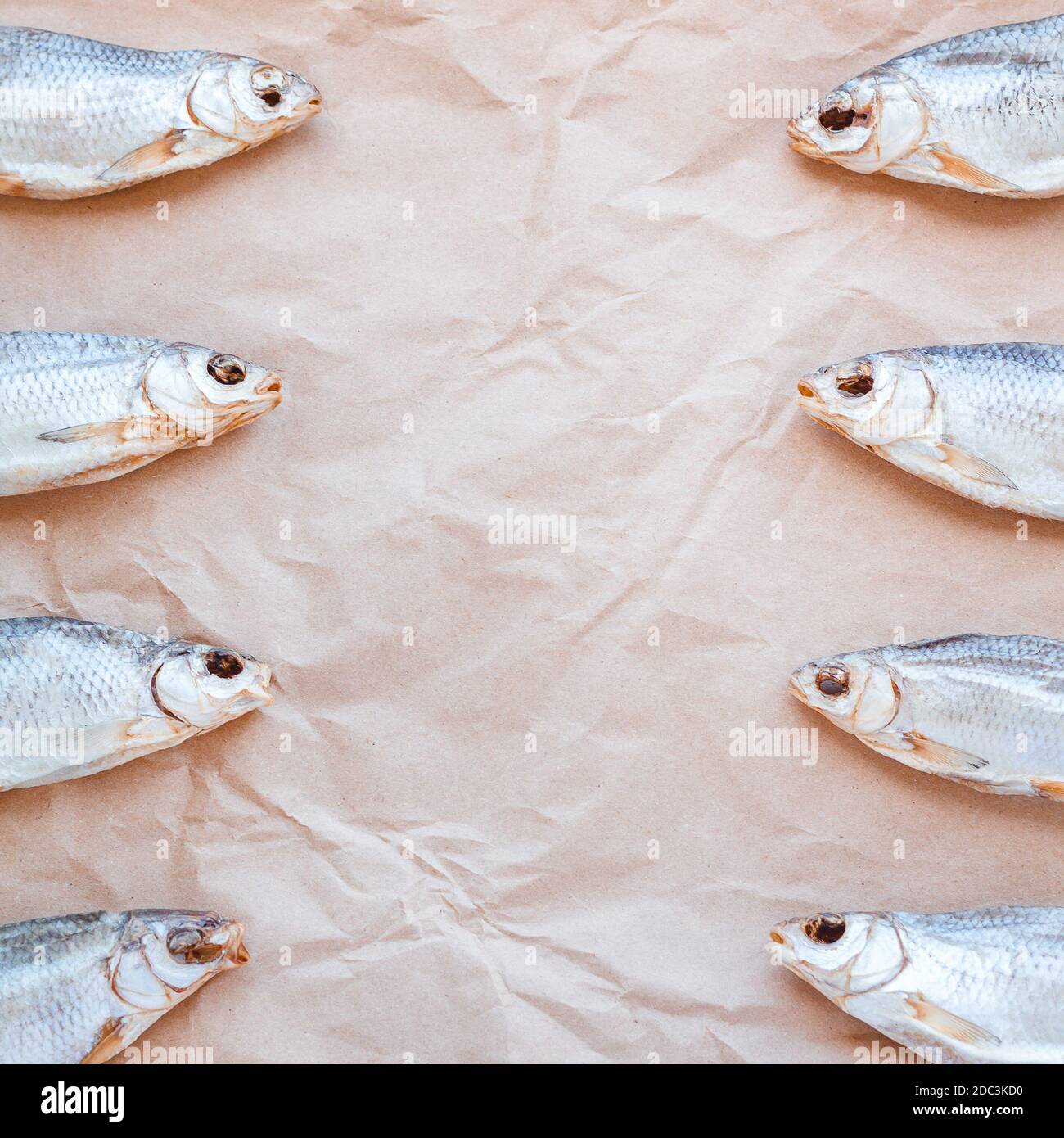 Bannière de modèle de poissons séchés sur fond de papier d'artisanat avec  espace vide pour le texte. Toile de fond plate de couverture de roach  salée. Affiche de collation de fruits de