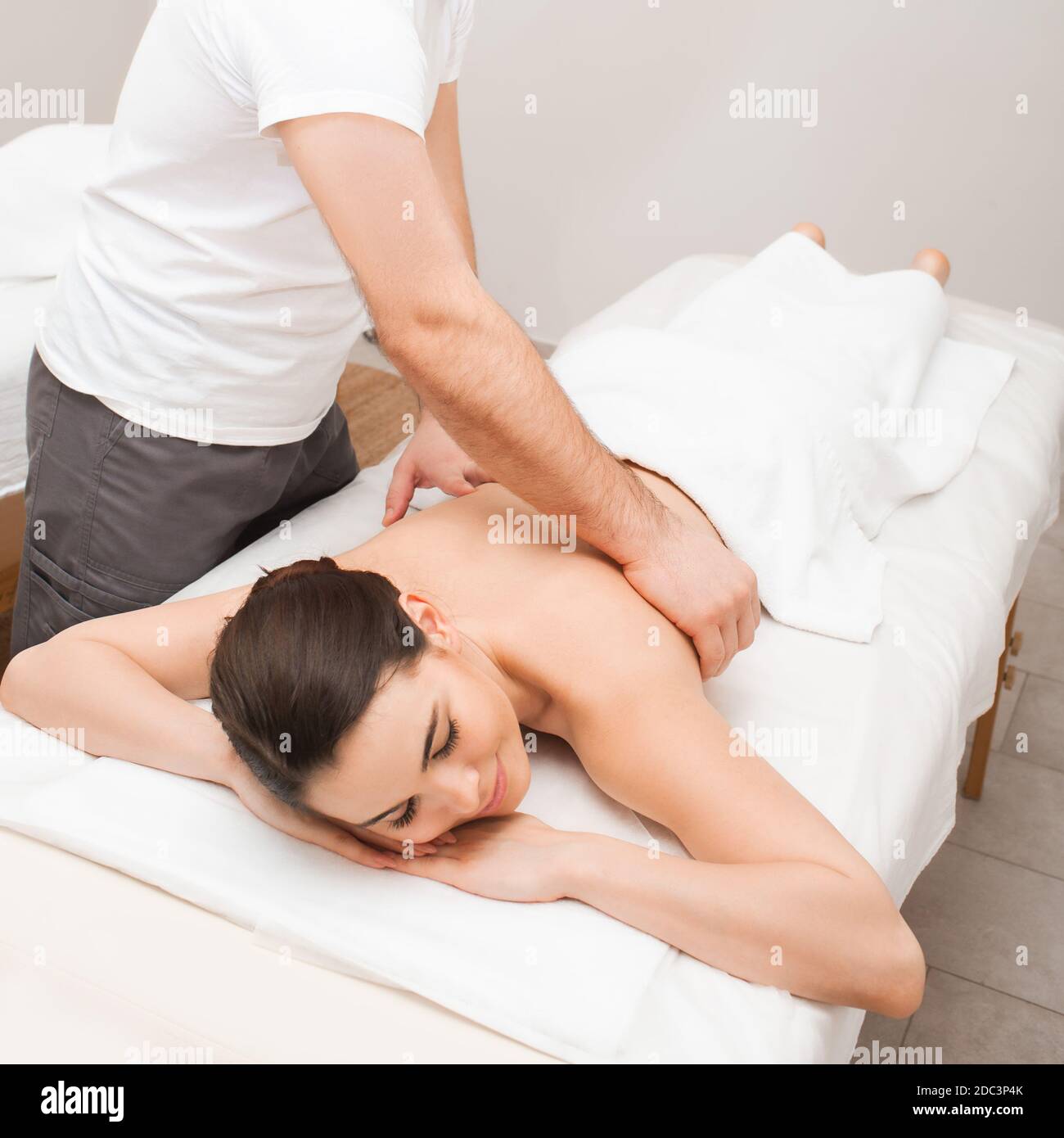 Massage relaxant classique. Femme de course mixte avec les yeux fermés profitant d'un massage dans le salon de spa Banque D'Images