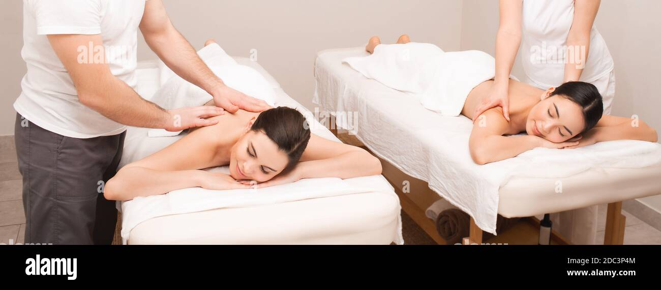 De belles amies de race mixte recevant un massage thérapeutique classique à la beauté spa Banque D'Images