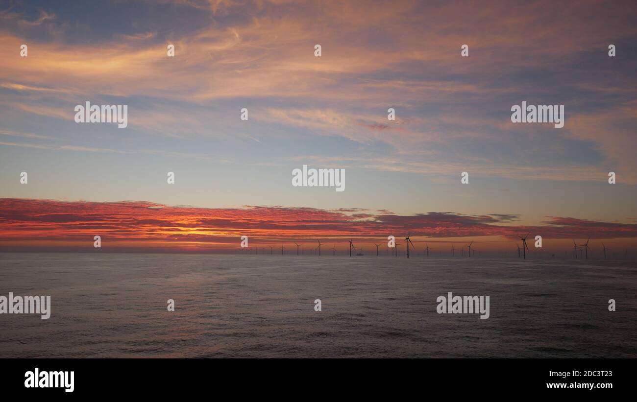 Coucher de soleil spectaculaire dans le parc éolien offshore en mer du Nord pendant temps parfait Banque D'Images