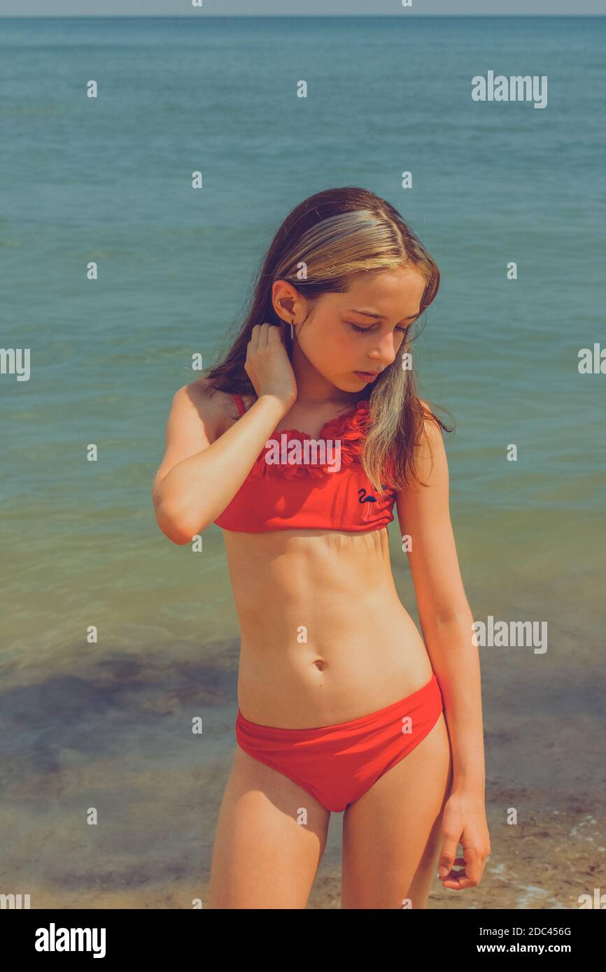 Fille enfant en maillot de bain près de la mer, le concept de repos et de  vacances. Adolescente près de la mer. Adolescente de 10 ans dans un maillot  de bain rouge.