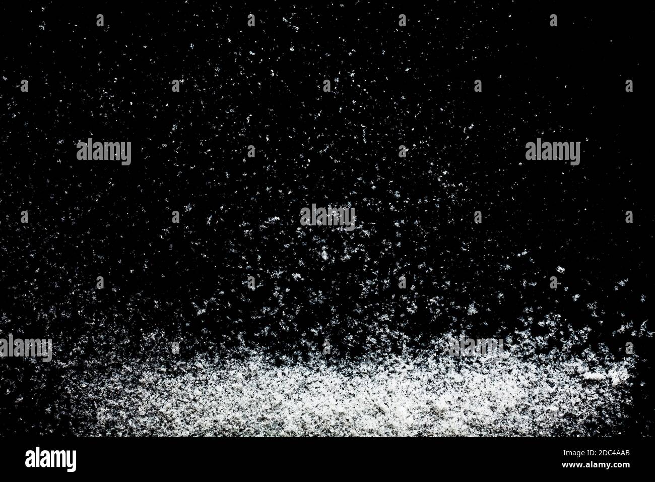 Particules de flocons de neige isolées sur fond noir. Modèle abstrait pour la conception Banque D'Images
