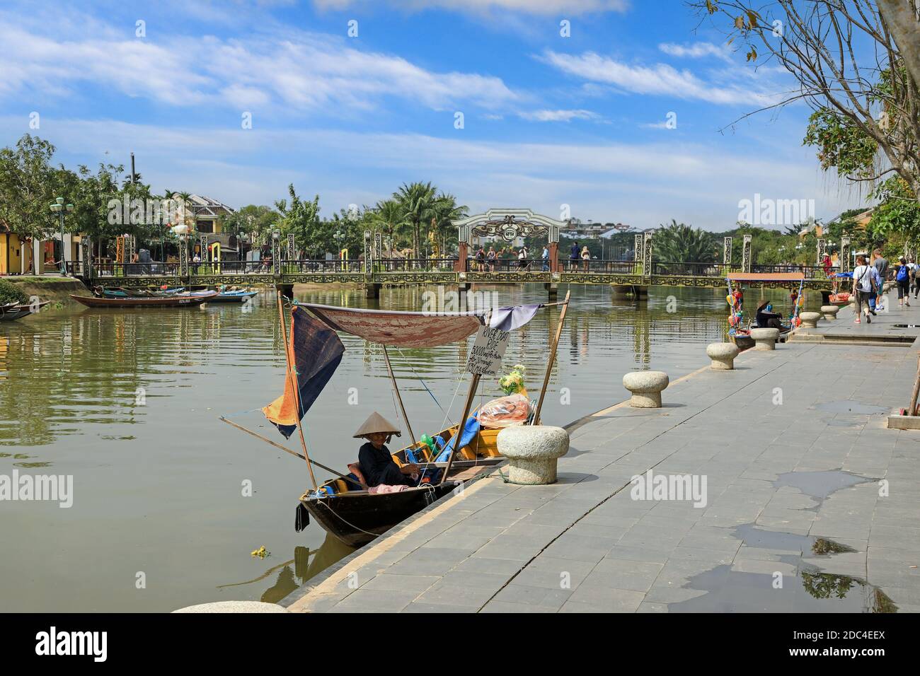 Une vieille femme vietnamienne sur un bateau sur la rivière Thu bon avec le pont Cau an Hoi en arrière-plan, Hoi an, Vietnam, Asie Banque D'Images