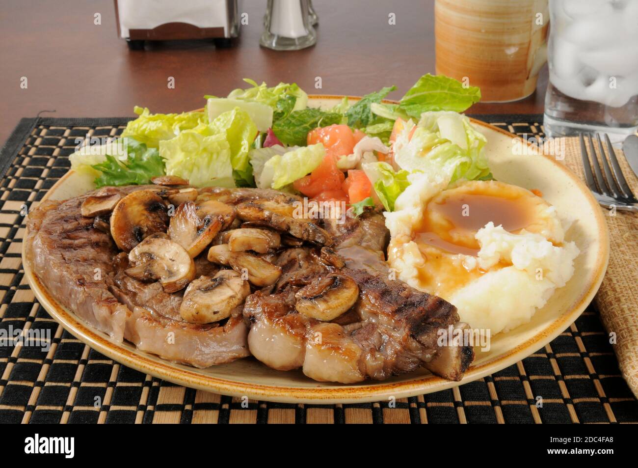 Steak de côtes grillées avec purée de pommes de terre et sauce et vert salade Banque D'Images