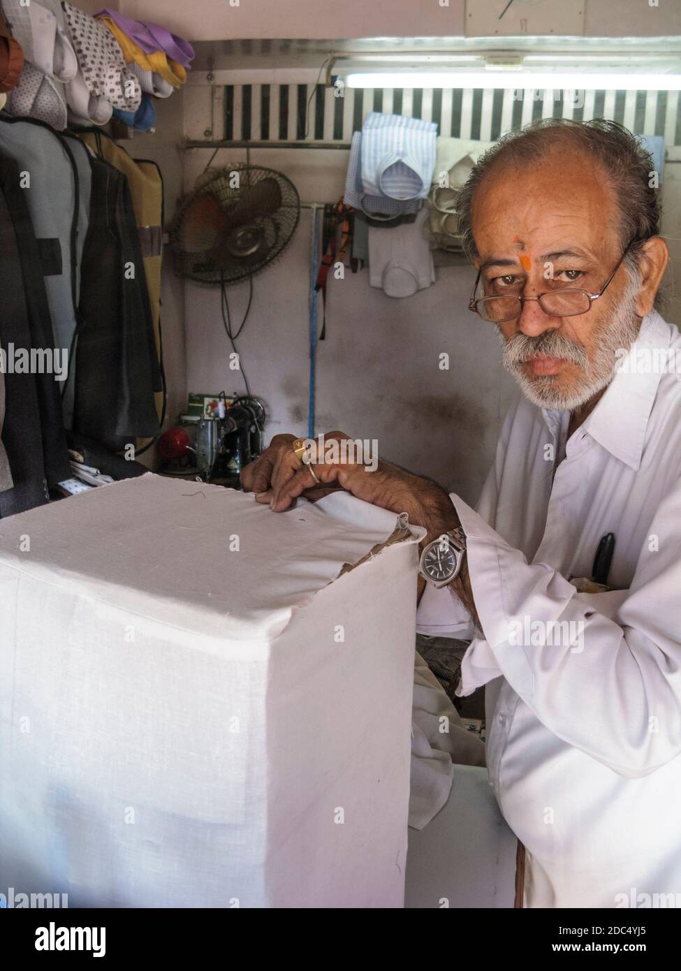 Inde, Rajasthan, Jodhpur. G. Walior, une boutique sur mesure. Il est en train de coudre un colis en coton blanc et de le sceller avec de la cire prête à être envoyée au Royaume-Uni par la poste. Banque D'Images