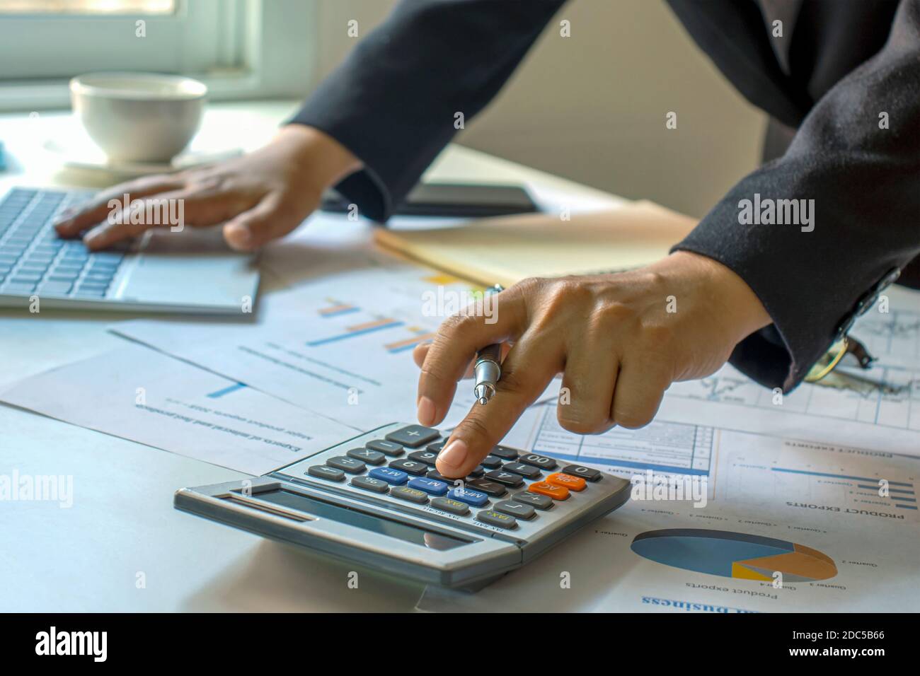 Les comptables de sexe masculin travaillent sur des documents financiers et des calculatrices pour les dépenses d'affaires et financières. Banque D'Images