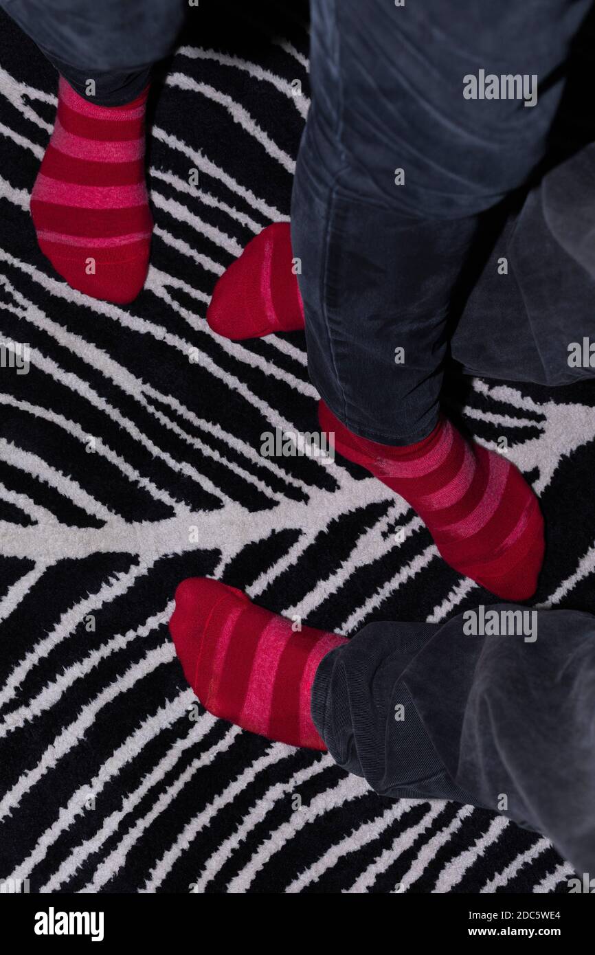 Chaussettes à rayures sur tapis à motifs Banque D'Images