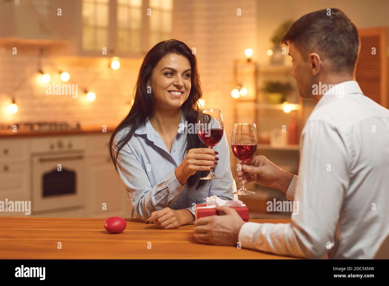 Jeune amoureux heureux couple regardant les uns les autres et se clinking verres avec vin Banque D'Images