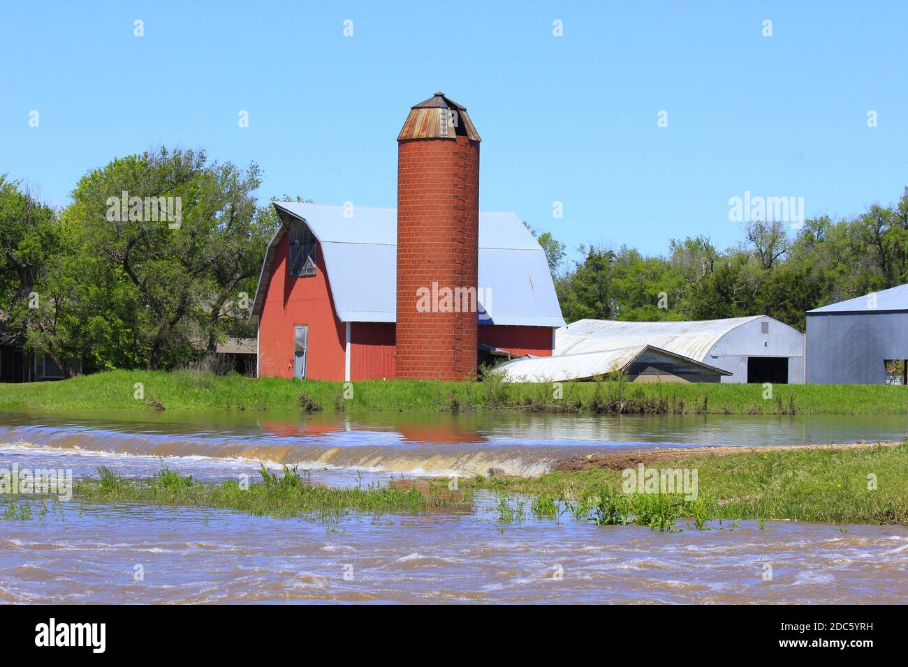 Kansas Red Barn et Silo avec des eaux d'inondation au printemps à Hutchinson Kansas USA dans le pays. Banque D'Images