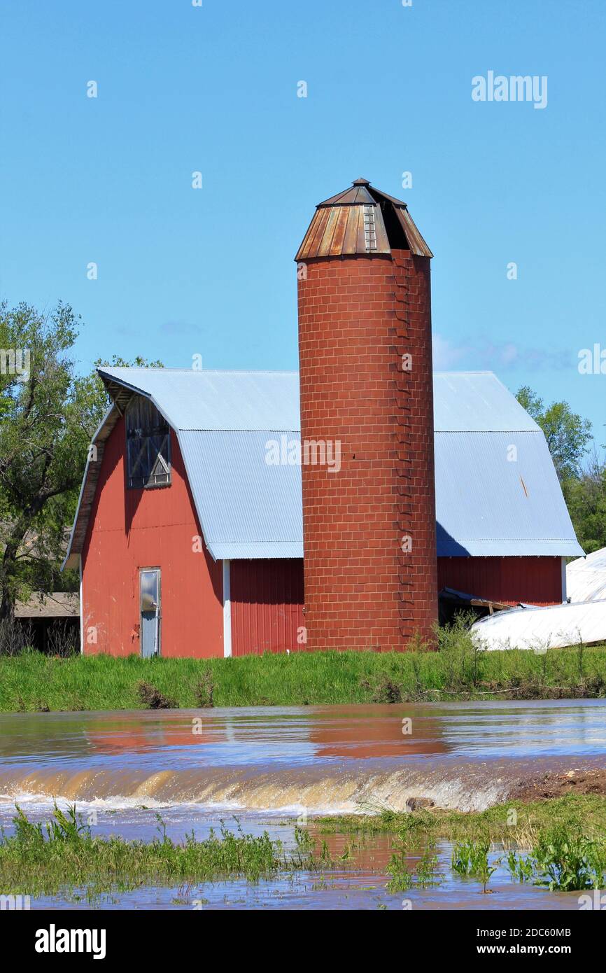 Kansas Red Barn et Silo avec des eaux d'inondation au printemps à Hutchinson Kansas USA dans le pays. Banque D'Images