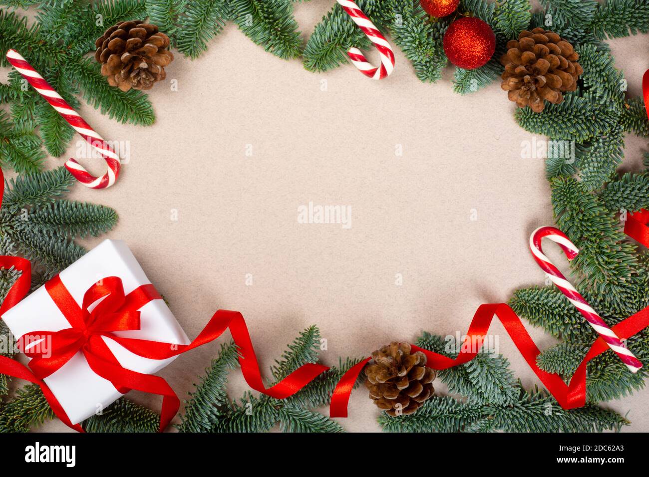 Noël sapin noble brindilles cadeau et décorations sur brun arrière-plan papier avec espace de copie pour le texte Banque D'Images