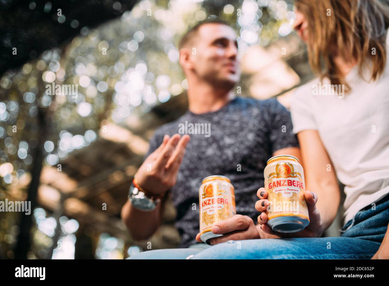 Beau jeune couple assis à boire de la bière et de célébrer Banque D'Images