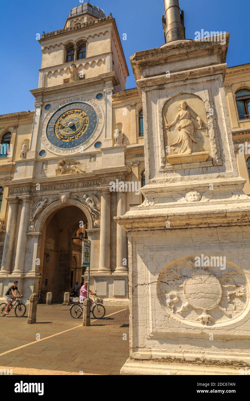 Cyclistes passant devant la façade ornée de Torre dell'Orologio sur la Piazza dei Signori, Padoue, Vénétie, Italie Banque D'Images