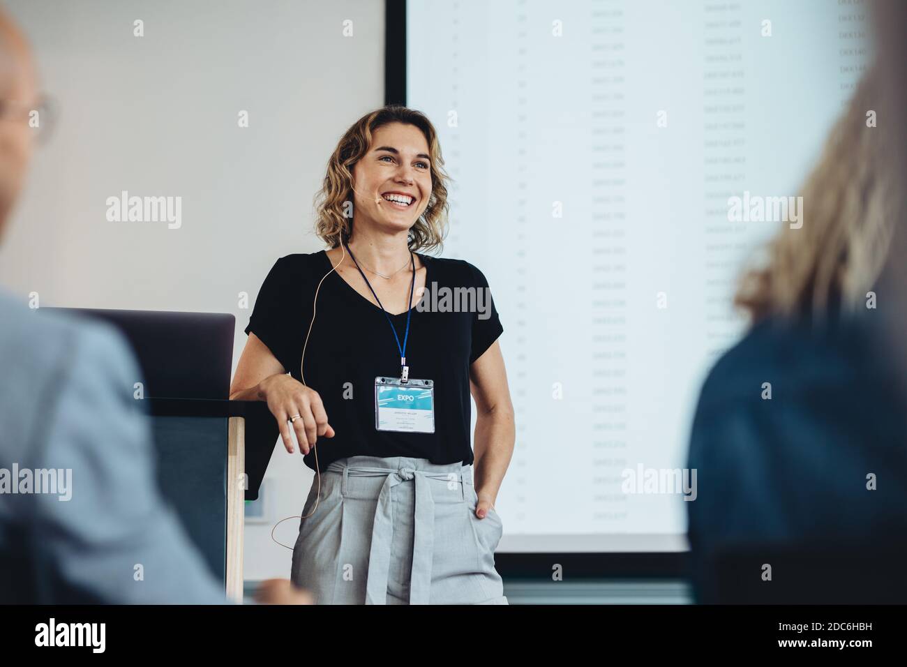 Femme d'affaires souriante qui prononce un discours lors d'une conférence. Présentation professionnelle réussie. Banque D'Images