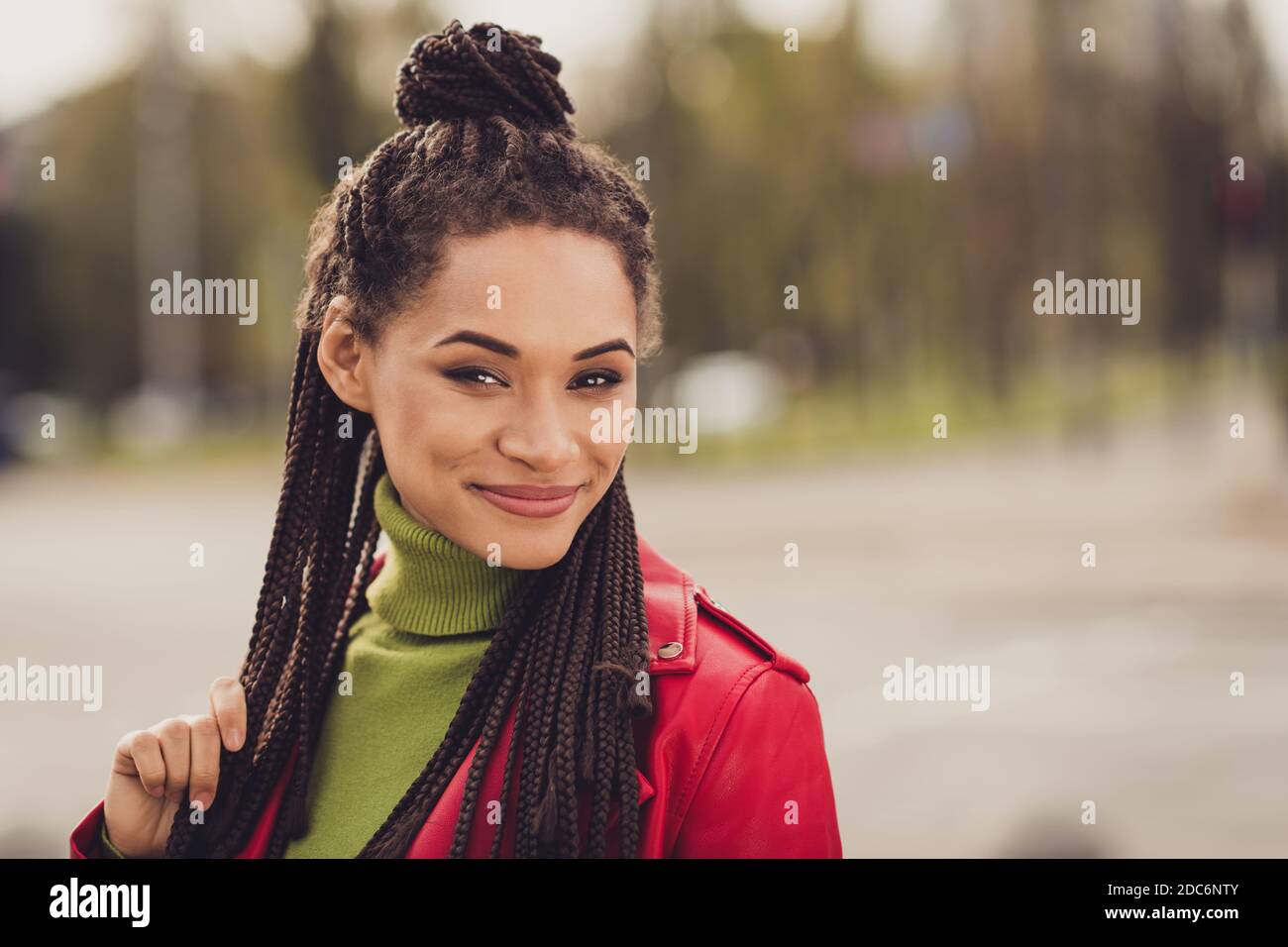 Photo de jeunes cheveux bruns attrayants afro femme sourire heureux les dreadlocks tactiles à la main apprécient la ville à pied le week-end Banque D'Images