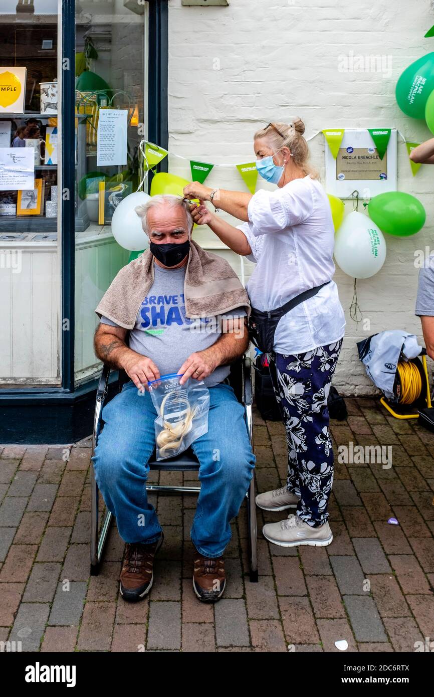 Des hommes qui ont rasé leurs cheveux pour recueillir de l'argent pour la Macmillan cancer Care Charity, High Street, Lewes, East Sussex, Royaume-Uni. Banque D'Images