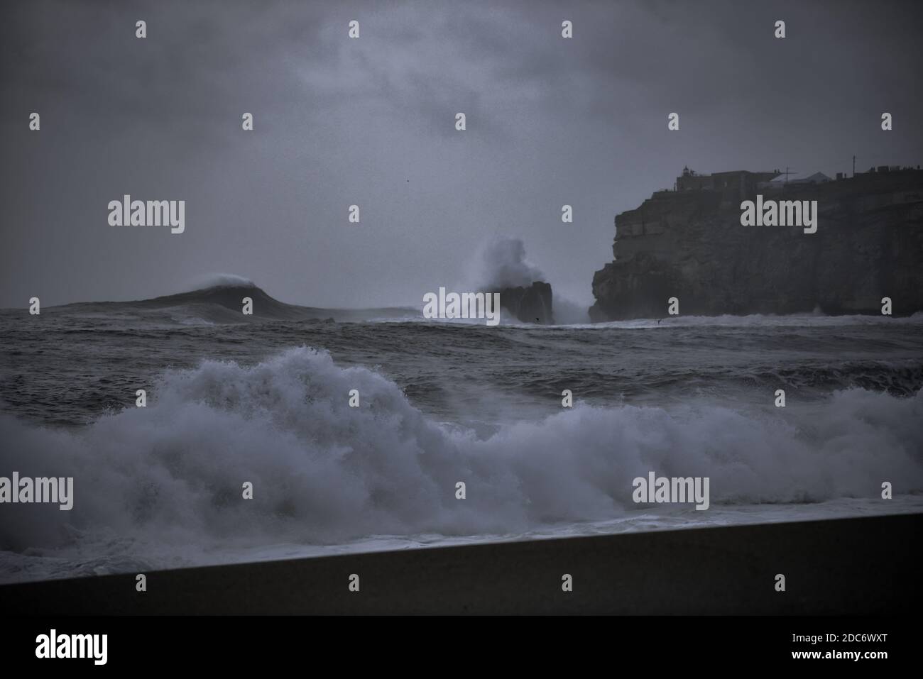 Moody image de Nazare Portugal au crépuscule avec de grandes vagues Banque D'Images