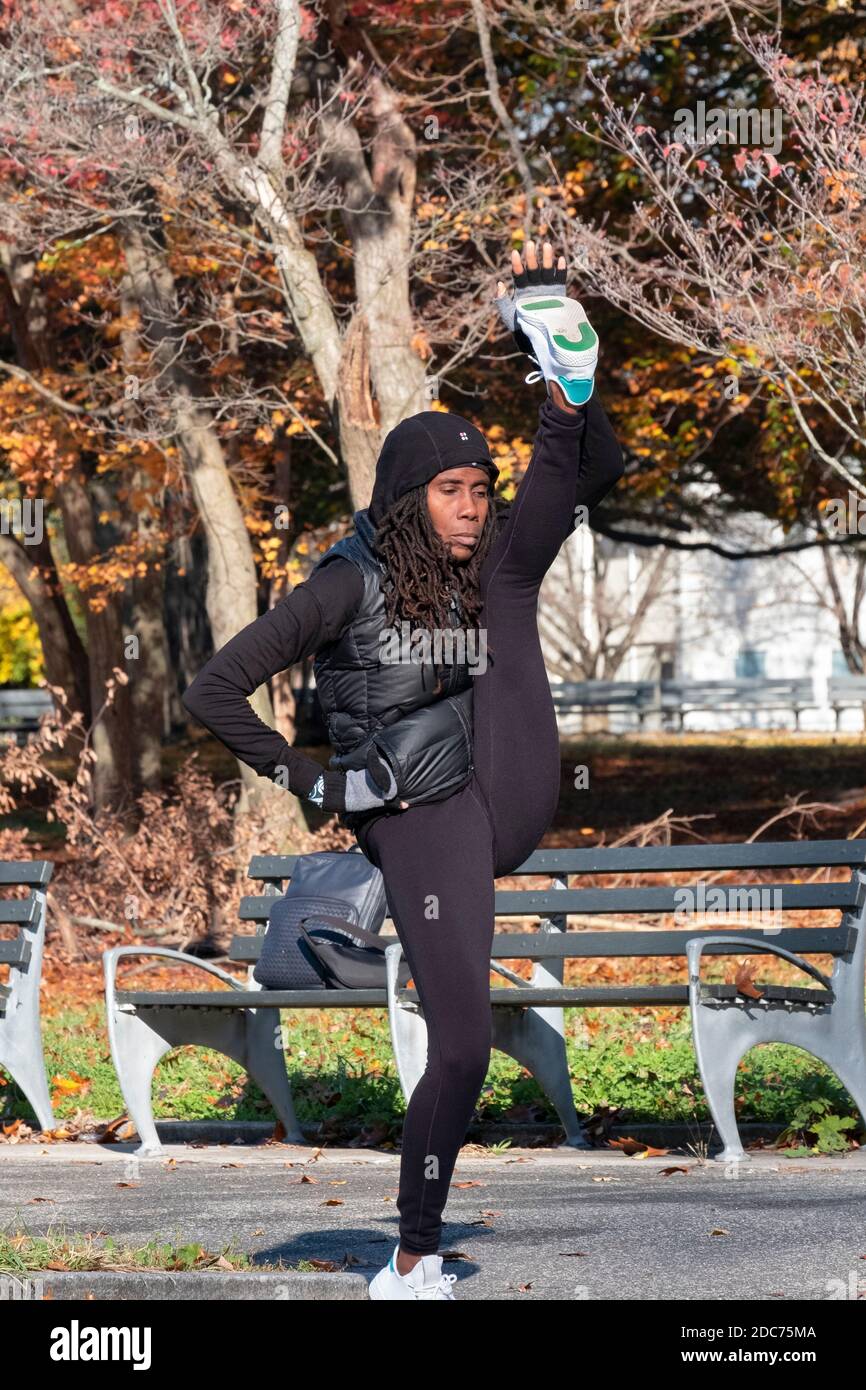 Une femme très flexible et agile fait des coups de pied de jambe élevés dans un parc à Flushing, Queens, New York City Banque D'Images Une femme très flexible et agile fait des coups de pied de jambe élevés dans un parc à Flushing, Queens, New York City Banque D'Images