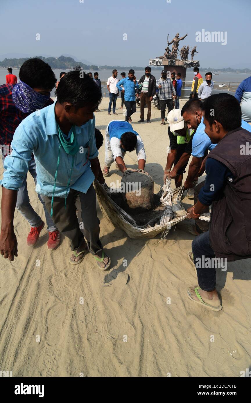 Guwahati, Assam, Inde. 18 novembre 2020. Les ouvriers indiens ont sorti un énorme Shiva Linga de la rivière Brahmaputra après qu'il a récupéré de la rivière pendant que les ouvriers nettoyaient la rivière à Guwahati Assam Inde le jeudi 19 novembre 2020.Shiva linga est une représentation abstraite ou aniconique de la déité hindoue Seigneur Shiva. Les hindous ont l'habitude d'offrir la prière avant Shiva Linga crédit: Dasarath Deka/ZUMA Wire/Alamy Live News Banque D'Images