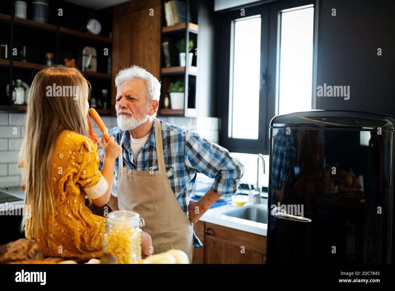 Grand-père souriant d'aider les enfants à cuisiner dans la cuisine Banque D'Images