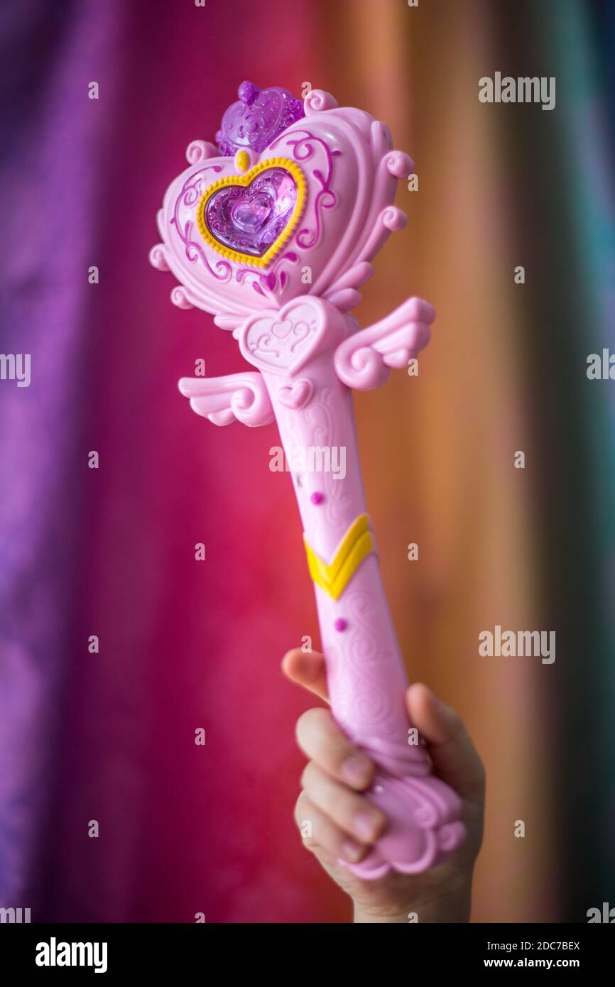 Une main d'enfant tenant une baguette magique Banque D'Images