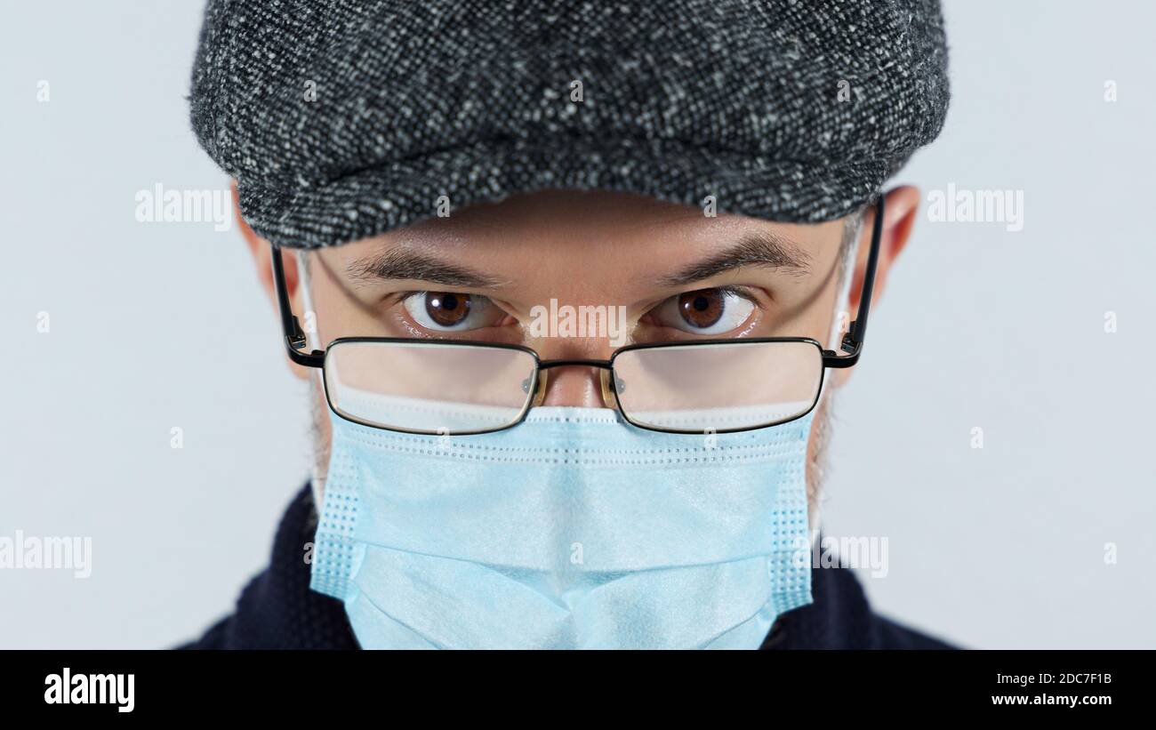 Homme avec des lunettes brumeuses causées par le port d'une protection covid masque Banque D'Images