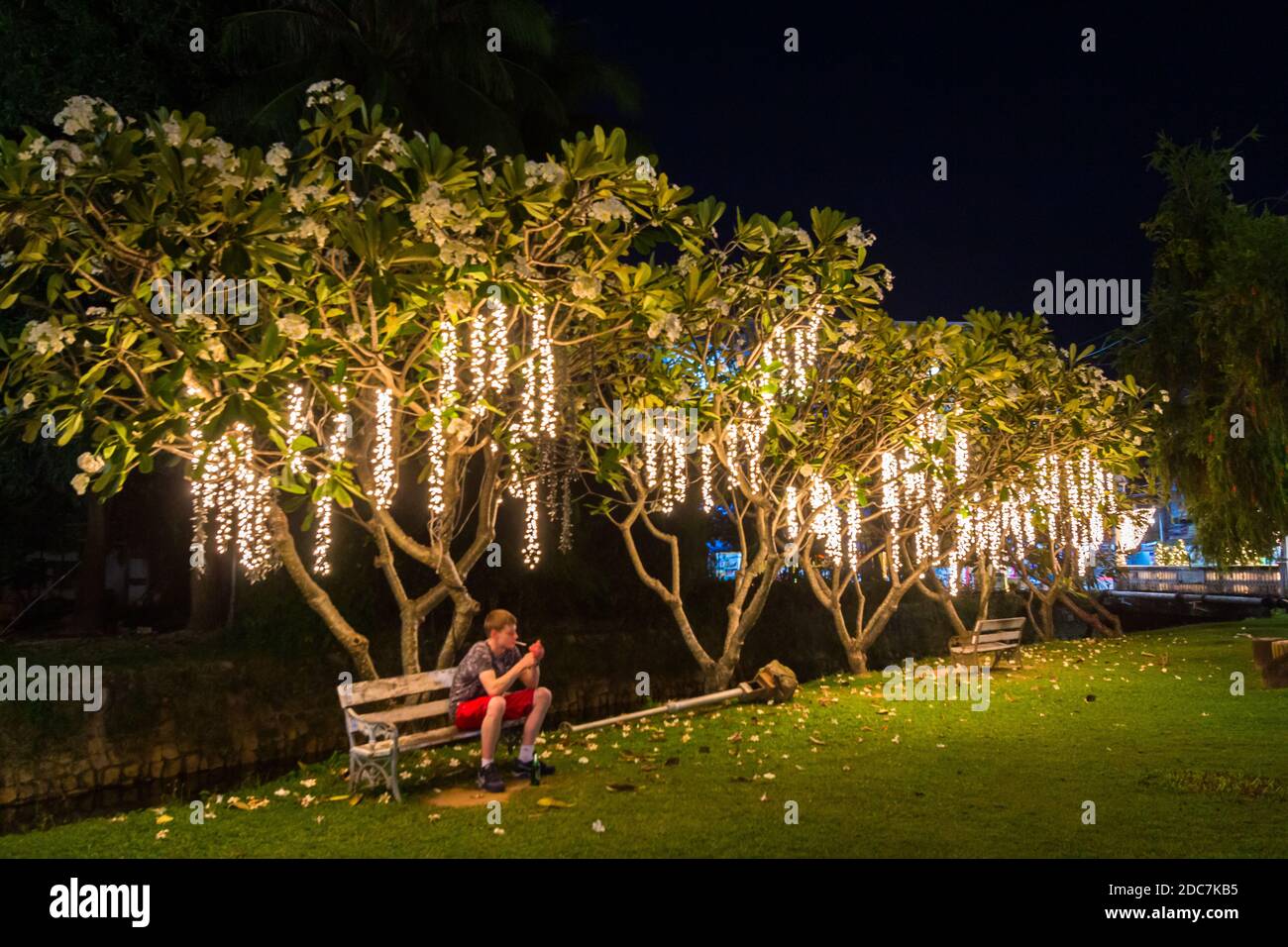 Un touriste étranger assis sur un banc de parc à Phuket, Thaïlande Banque D'Images