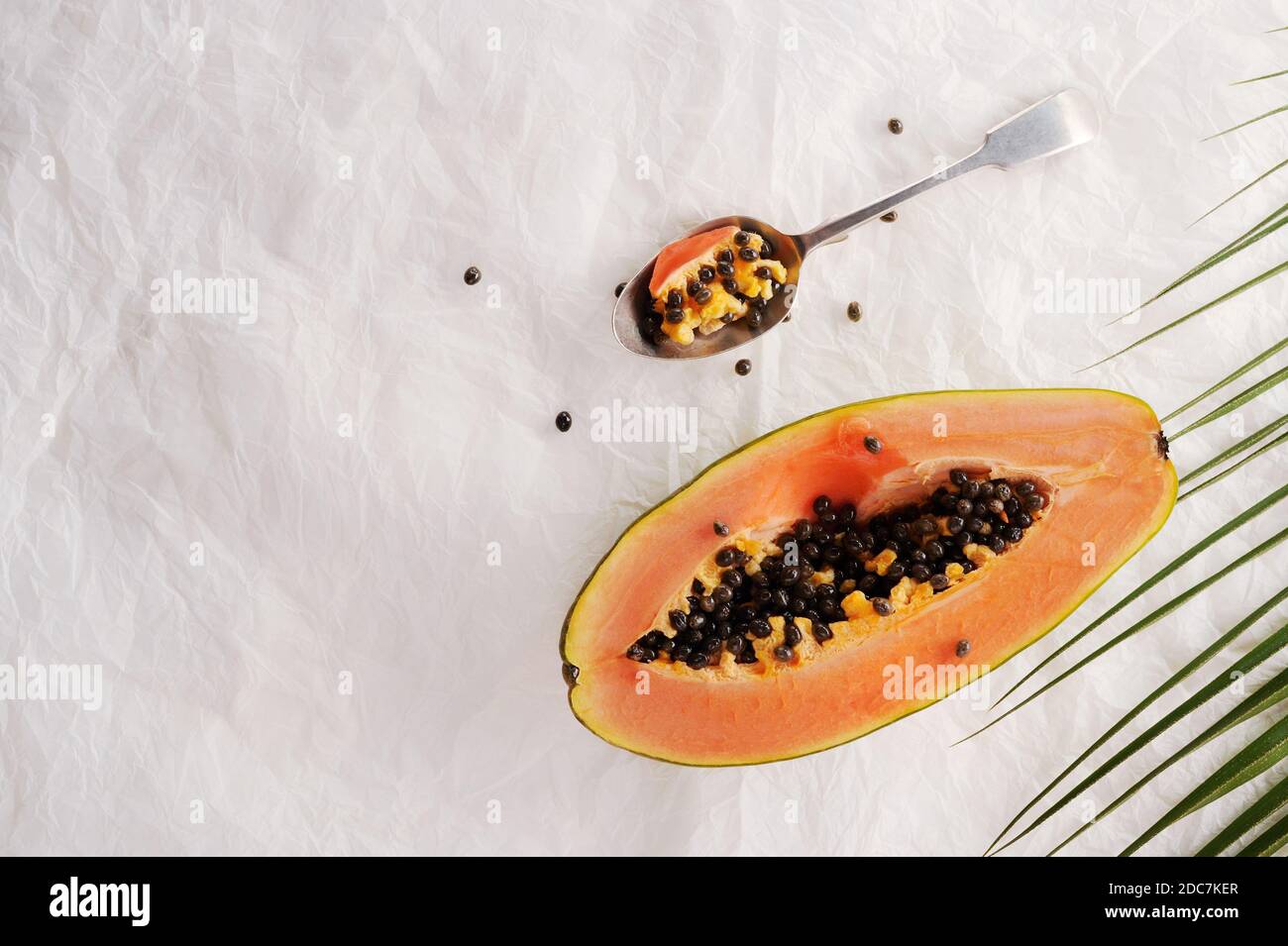 Mise en page créative en papaye. Moitié de papaye mûre avec cuillère sur le fond. Concept alimentaire. Arrière-plan d'été. Plan de travail avec espace de copie. Banque D'Images