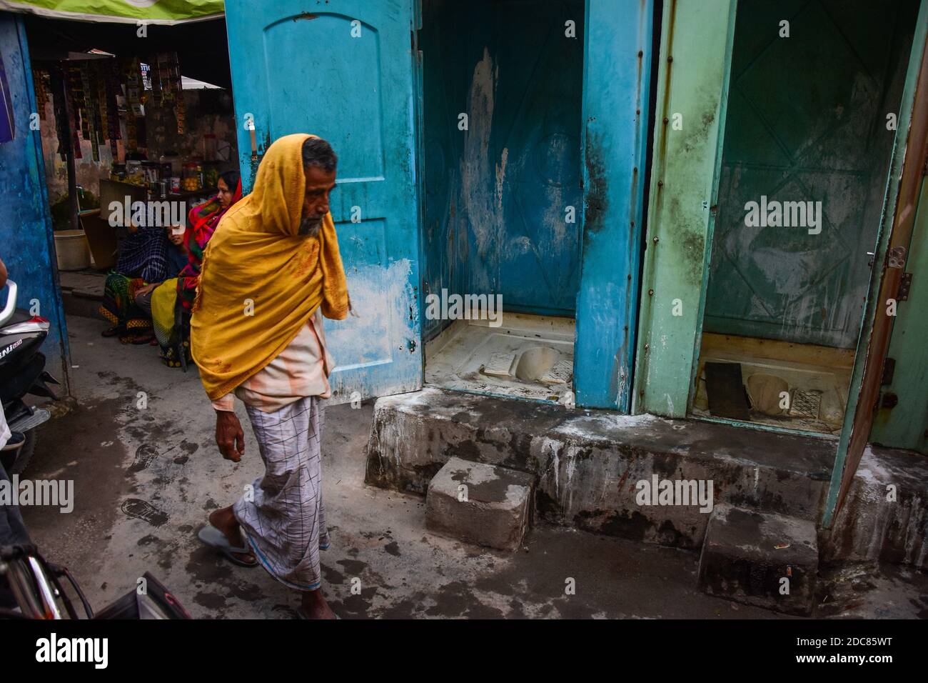 Un homme qui marche près des toilettes publiques dans la colonie de taudis  pendant la célébration.la Journée internationale des toilettes est une  célébration des Nations Unies qui célèbre les toilettes et sensibilise