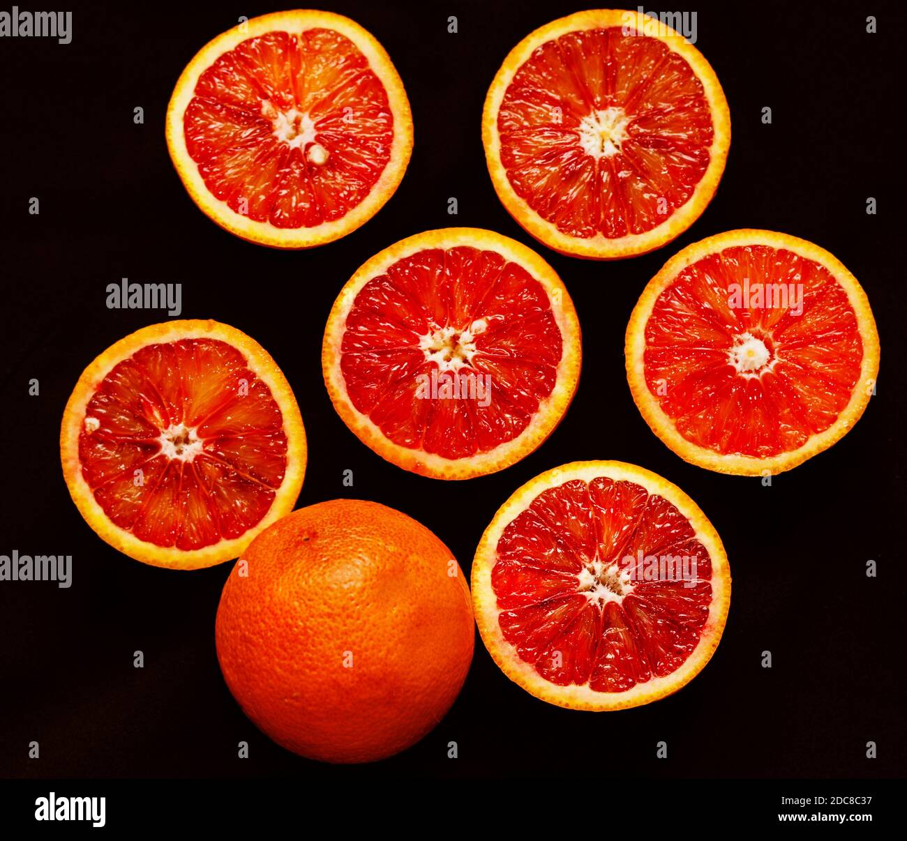 Moitiés d'oranges rouges mûres fraîches sur fond noir Banque D'Images Moitiés d'oranges rouges mûres fraîches sur fond noir Banque D'Images