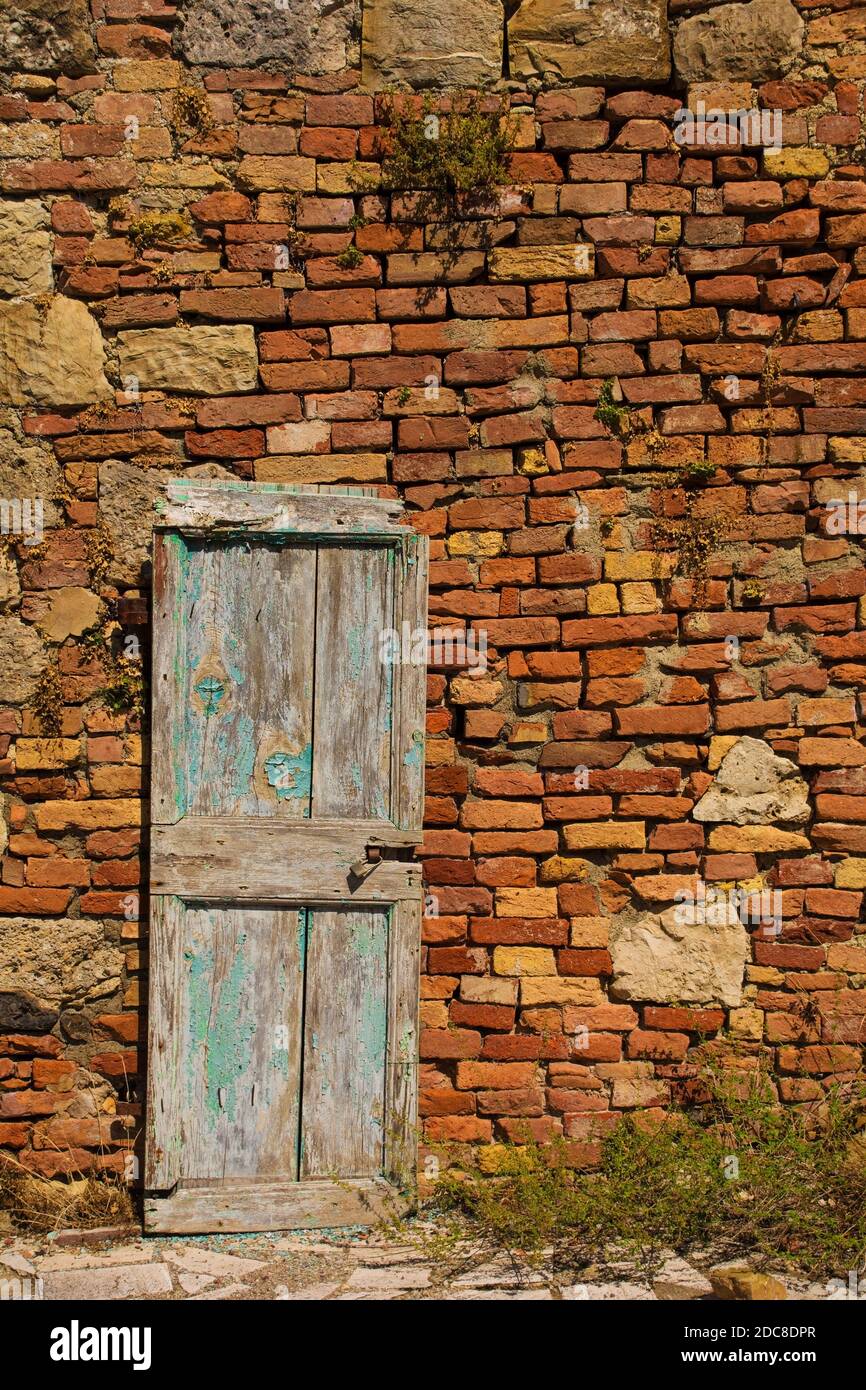 Une ancienne porte en bois dans un bâtiment désutilisé dans le village médiéval historique de Crevole près de Murlo dans la province de Sienne, Toscane, Italie Banque D'Images