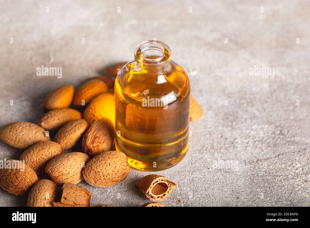 Huile de grains d'abricot dans un pot en verre, près de la table et des ingrédients. Huile de grains d'abricot et amandes d'abricot. Banque D'Images