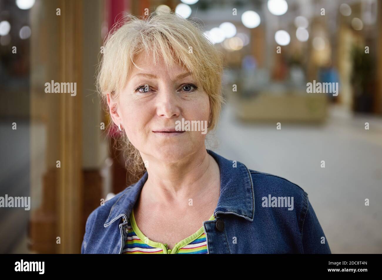 Beau portrait de vieux ladie. Une jolie femme âgée aux cheveux blonds courts se trouve dans le centre commercial. Banque D'Images