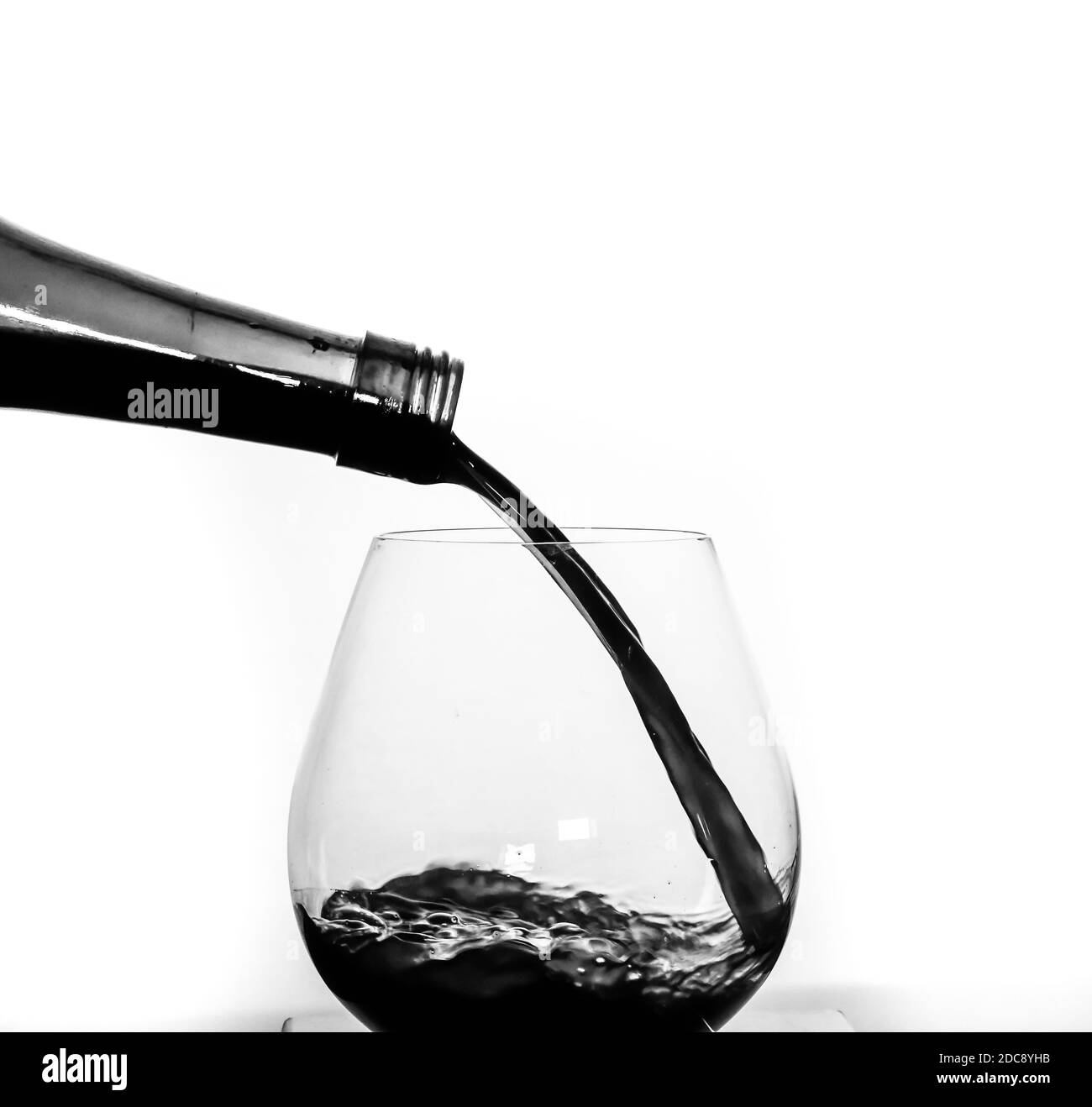 Verser le vin rouge dans un verre à vin Banque D'Images