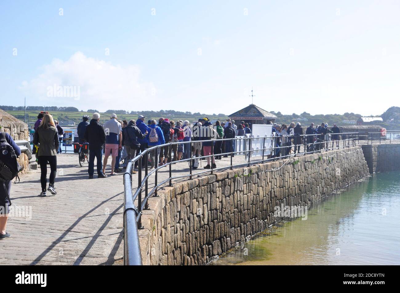 La longue file d'attente pour les bateaux inter-îles et d'excusion spéciale au bureau de réservation sur le quai de St Mary's dans les îles de Scilly, Cornouailles. ROYAUME-UNI Banque D'Images