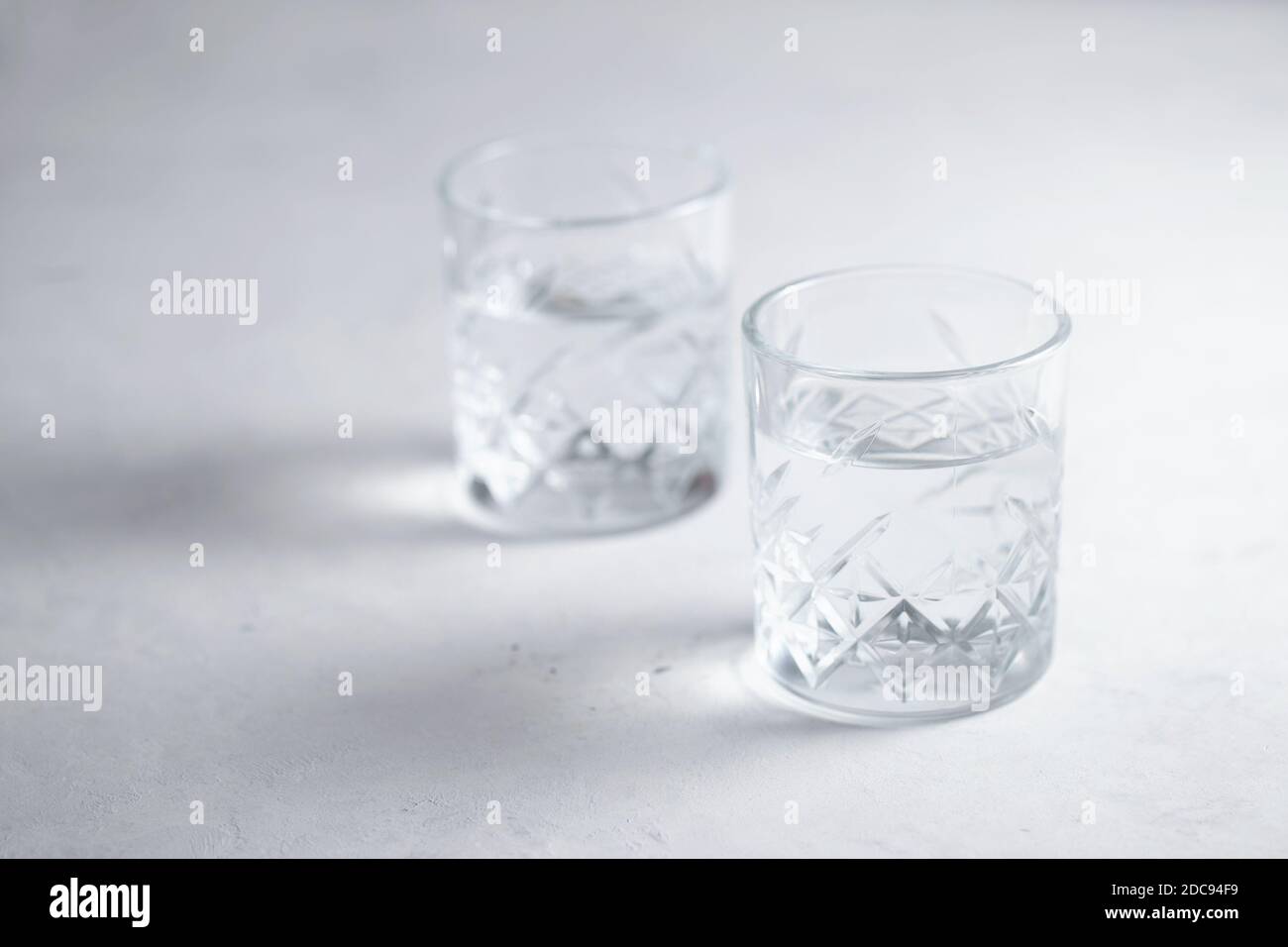 Deux verres d'eau ou de liquide transparent sur la table un mode de vie sain Banque D'Images