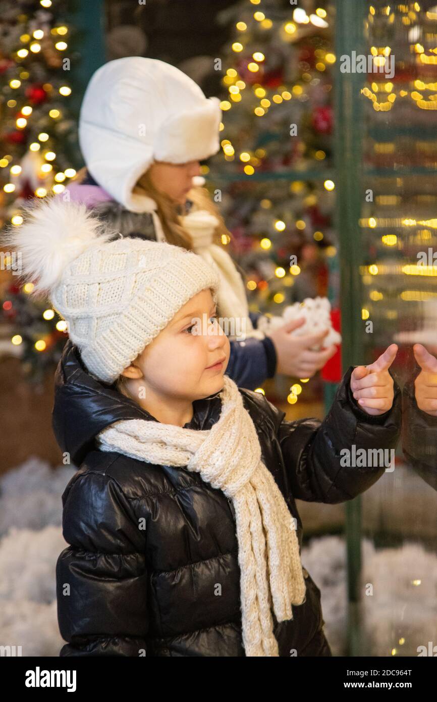 Des enfants heureux examinant les jouets dans la fenêtre du magasin ensemble Banque D'Images