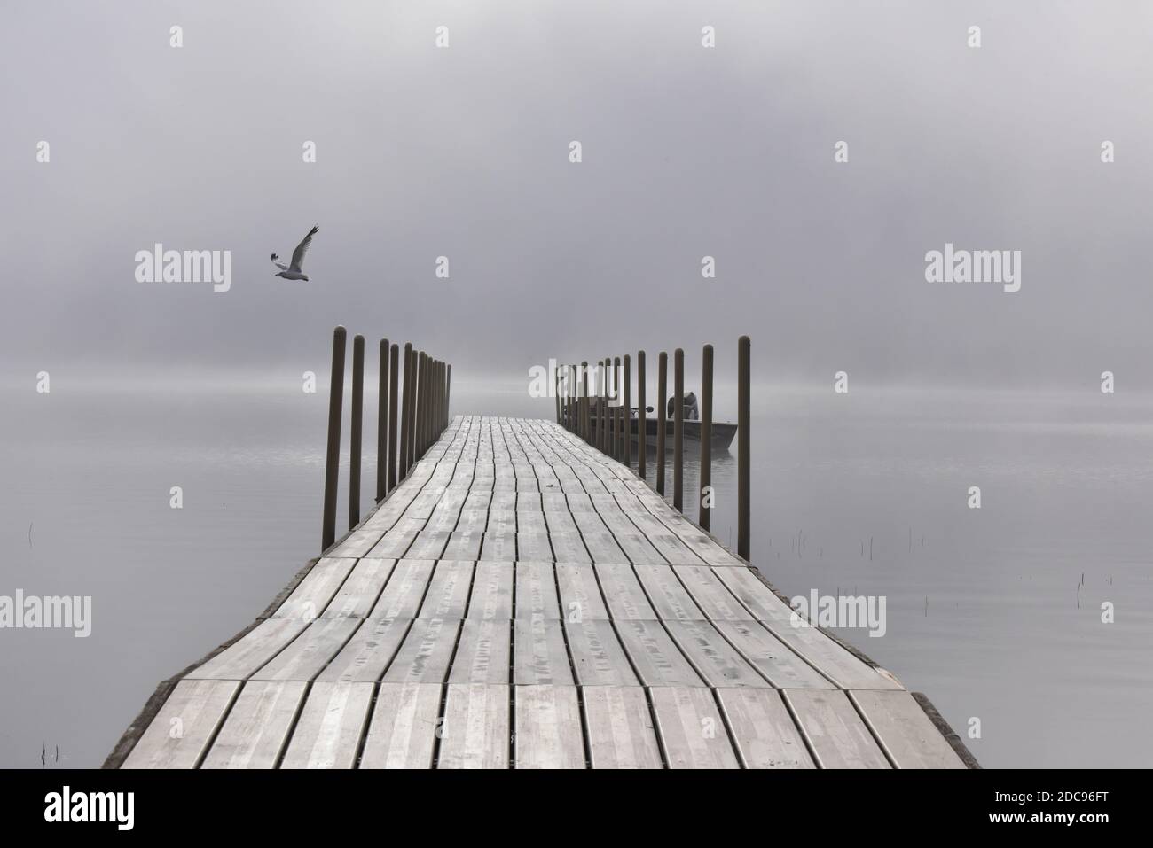 quai de pêche vide sur le lac sur un brouillard matin en été Banque D'Images